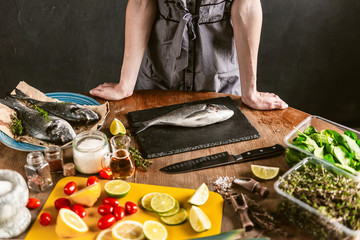 woman chef preparing fresh raw dorado fish