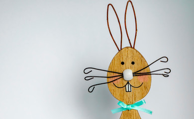 Wooden easter bunny in front of a light background as a basis for an Easter card.