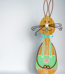 Wooden easter bunny in front of a light background as a basis for an Easter card.