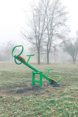 Empty children's playground on a foggy autumn morning