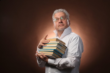 Scientific thinker, philosophy, elderly gray-haired man in a white shirt with a books, with studio light