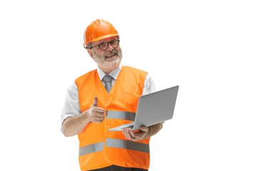 The builder in a construction vest and an orange helmet with laptop. Safety specialist, engineer, industry, architecture, manager, occupation, businessman, job concept