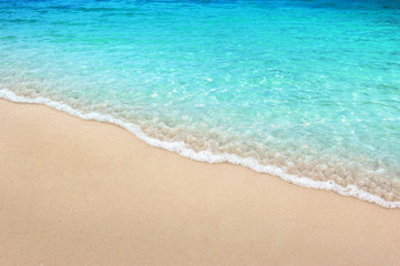 Fototapeta na wymiar Soft blue ocean wave on clean sandy beach summer concept background