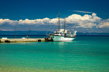Ship on blue paradise water of Toroneos kolpos gulf, Halkidiki, Greece
