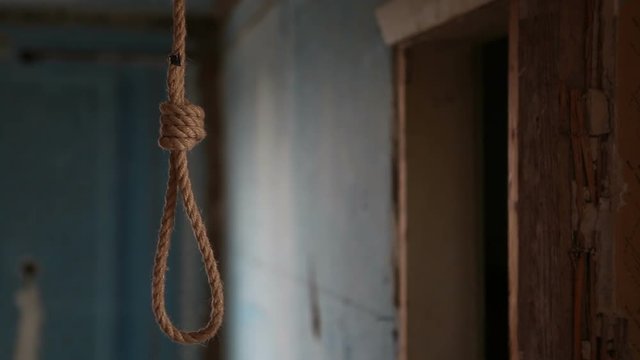 A rope loop for suicide hangs in a wooden hut. Suicide in an abandoned house