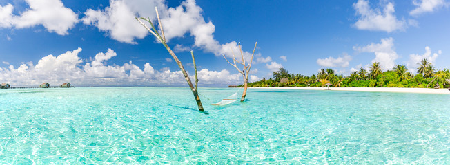 Romantic cozy hammock in Maldives islands landscape, perfect tropical beach by the sea. Sunny...