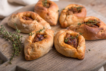 Rasstegai pie with fish filling. Traditional meal of Russian cuisine. Russian dolls in the...