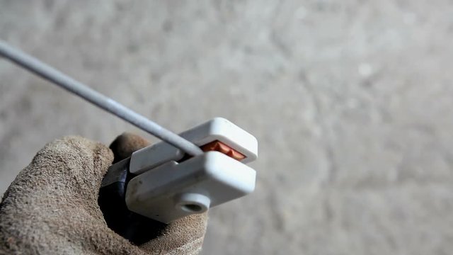 The welder inserts the electrode into the holder of the welding machine.