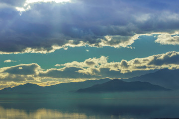 Salton Sea with Calm Water and Sun Breaking Through Clouds
