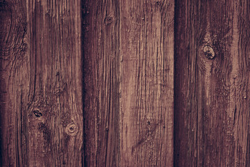 Brown wooden retro table. Red wooden wall background in rustic style. Old brown wall wood vintage floor. Wooden fence maroon painted. Wood brown boards texture.