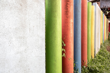 Fences that use round concrete with square concrete styles and paint many colours.
