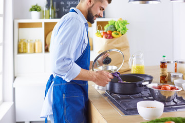 Smiling and confident chef standing in large kitchen