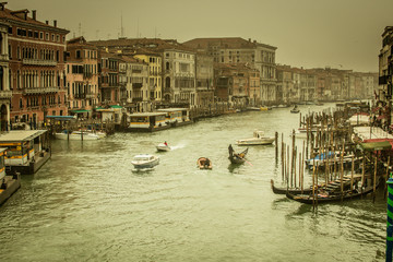 Fototapeta na wymiar Venice / Italy 19 february 2019 :view of the Canal in Venice from Rialto bridge,gondolas are crossing the river and people enjoy their winter vacations