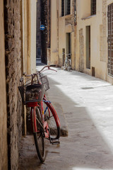 Red bike on a narrow street in the old town. Italy, Florence