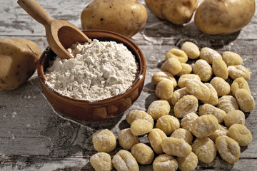 gnocchi di patate su tavolo rustico con farina e patate dall'alto