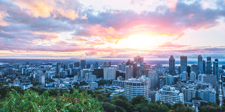 Beautiful sky and sunrise light over Montreal city in the morning time. Amazing view from Mont-Royal with colorful blue architecture. Stunning panorama of Montreal downtown with business buildings.