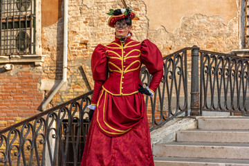 Fototapeta na wymiar taly, Venice, 2019, carnival, people with beautiful masks walk around Piazza San Marco, in the streets and canals of the city, posing for photographers and tourists, with colorful clothes.