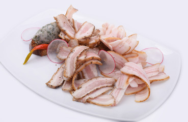 Close up of delicious traditional sliced ​​lard with radish and chili pepper on a  white plate isolated