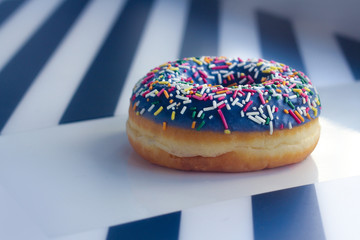 sweet Donut with icing and color dusting, on a white background, side view