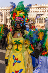 Italy, Venice, 2019, carnival, people with beautiful masks walk around Piazza San Marco, in the streets and canals of the city, posing for photographers and tourists, with colorful clothes.