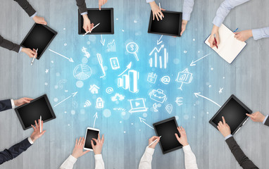 Group of people with devices in hands making reports together on laptop, tablet, notebook
