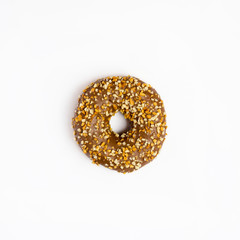 A single chocolate glazed donut with nuts isolated white background, top view