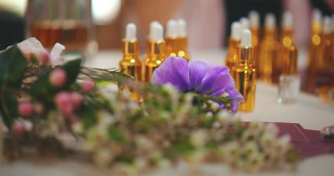 Close up view of bottles with aroma oils and flowers