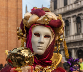 Fototapeta na wymiar Italy, Venice, 2019, carnival, people with beautiful masks walk around Piazza San Marco, in the streets and canals of the city, posing for photographers and tourists, with colorful clothes.