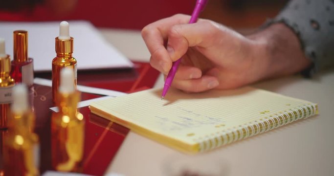 Close up of perfumer taking notes at perfumery courses