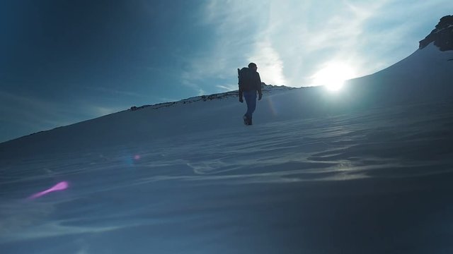 Hiker with backpack climbing top of mountain, mountaineering concept. Man walking snow, hiking in winter. Trekking adventure, people in nature concept. Epic sunset view snow mountain landscape,