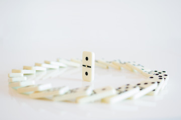 Concept of the leader with domino tiles falling in a circle and one standing