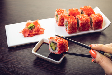 sushi roll dipped in soy sauce