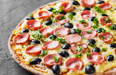 Pizza with Mozzarella cheese, olives, ham, tomato sauce, sausage, pepper, Spices. Italian pizza Italian pizza on wooden table background 