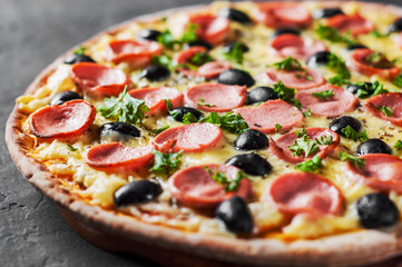 Pizza with Mozzarella cheese, olives, ham, tomato sauce, sausage, pepper, Spices. Italian pizza Italian pizza on wooden table background 
