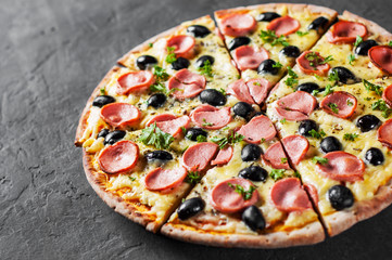 Pizza with Mozzarella cheese, olives, ham, tomato sauce, sausage, pepper, Spices. Italian pizza Italian pizza on wooden table background 