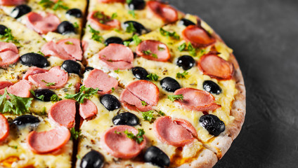Pizza with Mozzarella cheese, olives, ham, tomato sauce, sausage, pepper, Spices. Italian pizza Italian pizza on wooden table background 