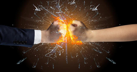 Two hands fighting and breaking a glass into small pieces
