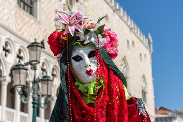 Fototapeta na wymiar Italy, Venice, carnival, 2019, people with beautiful masks walk around Piazza San Marco, in the streets and canals of the city, posing for photographers and tourists, with colorful clothes.