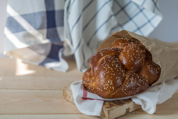 Challah bread on a wood plate on wooden table / white background with copy space