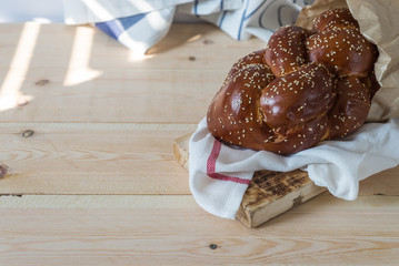 Challah bread on a wood plate on wooden table / white background with copy space
