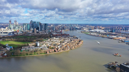 Fototapeta premium Aerial bird's eye view photo taken by drone of Canary Wharf skyline as seen from river Thames with beautiful cloudy sky, Isle of Dogs, London, United Kingdom