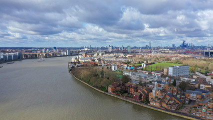 Fototapeta na wymiar Aerial bird's eye view photo taken by drone of Canary Wharf skyline as seen from river Thames with beautiful cloudy sky, Isle of Dogs, London, United Kingdom