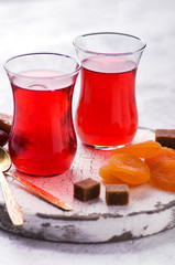 Close-up of fruit tea in turkish glasses, dried apricots and sugar cubes