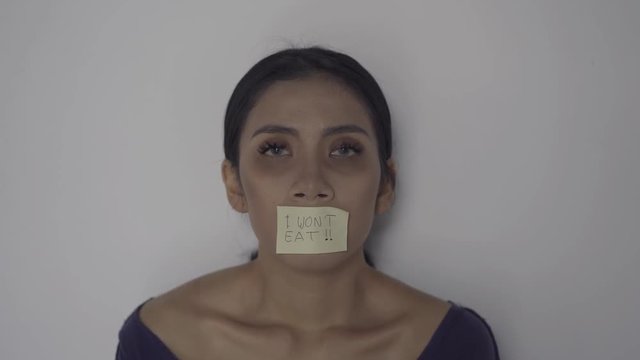 Skinny anorexic woman with text of I Won't Eat on her mouth. Shot in 4k resolution