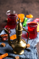 Obraz na płótnie Canvas Fruit tea in turkish glasses, vintage kettle and oriental sweets