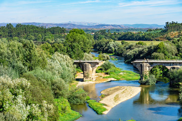 Fototapeta na wymiar Beautiful river landscape with a destroyed old bridge.