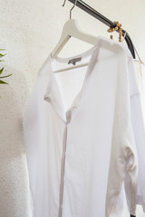 White blouse on a hanger on white background.close up.
