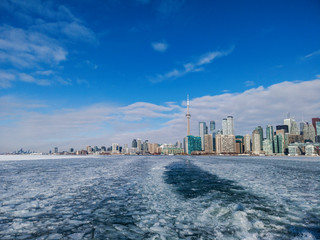 Naklejka premium View of Toronto city skyline form a boat as it crosses the frozen Lake Ontario