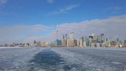 Naklejka premium View of Toronto city skyline form a boat as it crosses the frozen Lake Ontario