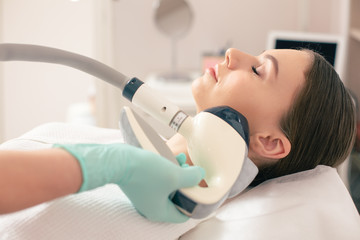 Cosmetician wearing gloves while making non-invasive body modeling procedure